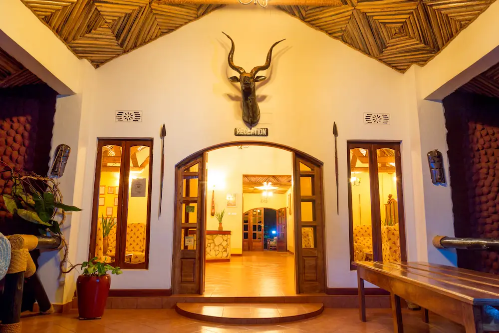 Lodge entrance hall with carved doors and mounted kudu horns