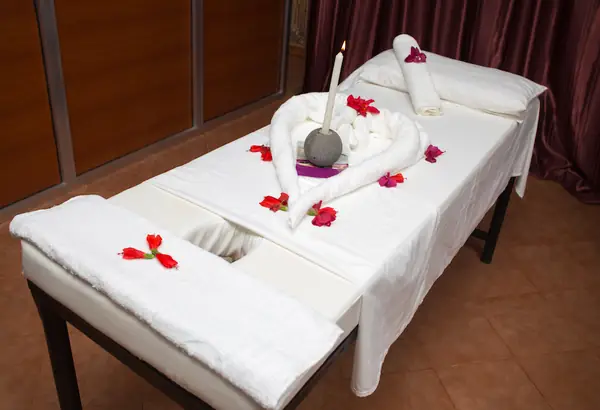 Massage table decorated with towel swans and petals