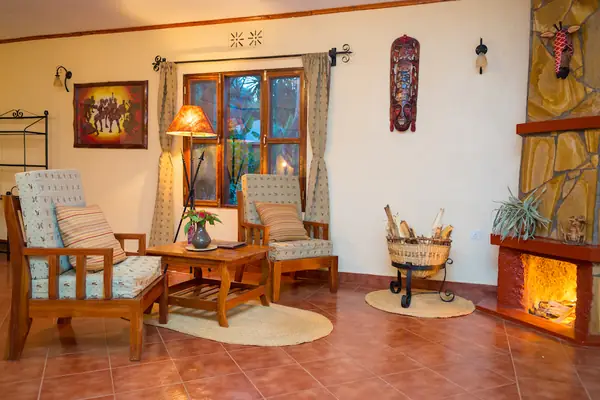 Rondavel lounge with armchairs and a stone fireplace